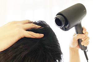 ドライヤーをかける男性